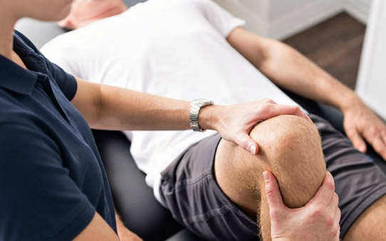 Kinesiólogo tratando una rodilla